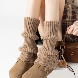 Detail of coffee brown cable knit leg warmers with vintage ribbed pattern and wool texture