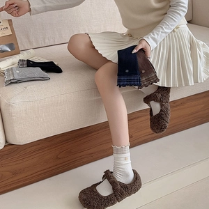 Détail de chaussettes en tricot avec poignets en dentelle à carreaux et boutons fleuris