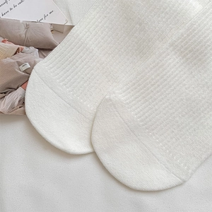 Detailed macro view of white ribbed crew socks featuring soft cotton fabric texture