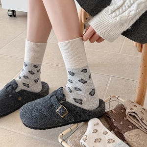 Detail of wool clogs with leopard print socks and adjustable metal buckle