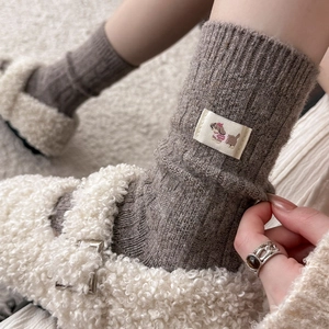 Detailed knit texture of wool socks featuring a cute cartoon dog patch on the ankle