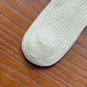 Macro view of ribbed wool blend socks showing premium knitting texture and toe seam detail