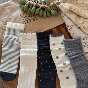 Detail of diverse wool blend socks featuring polka dots, stripes and lace textures