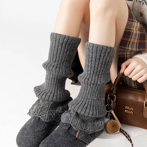 Detailed knit texture of grey ribbed leg warmers featuring warm winter crochet style