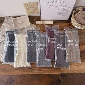 Détail de jambières en tricot colorées avec bords festonnés dans un emballage cadeau