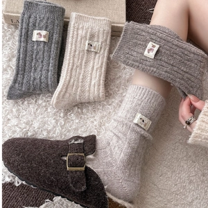 Detailed knit texture of wool socks featuring cute dog patch and ribbed vintage pattern