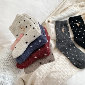Close-up of wool socks featuring retro polka dots and cute animal embroidery detail