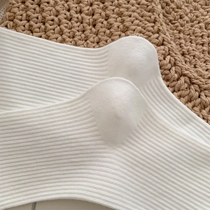Gros plan de chaussettes mi-mollet blanches avec texture à rayures verticales rétro