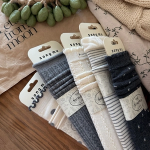 Assorted vintage knit socks with polka dots and stripes in a warm wooden setting