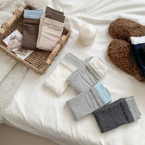 Detail of ribbed cotton mid-calf socks with dual-tone cuffs in various neutral colors