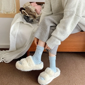 Detailed close-up of light blue ribbed wool socks with white bow embroidery on cuffs
