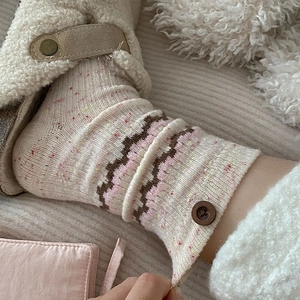 Detailed knit of wool socks with colorful dots, ethnic wave pattern and wooden button detail