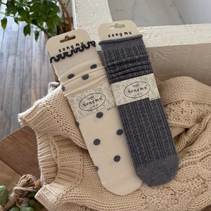 Detail of vintage wool socks with polka dots and ruffled edges on a wooden background