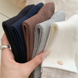 Gros plan de cinq paires de chaussettes mi-mollet côtelées aux textures tricotées