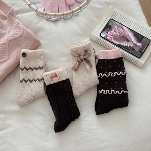 Detail of wool blend socks featuring bow ties, wood buttons and pink wave trim embroidery