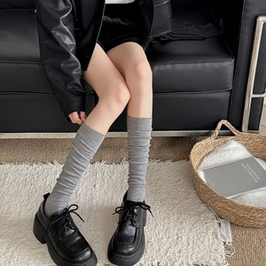 Calze grigie a righe verticali stile slouchy con scarpe platform nere ed eleganti