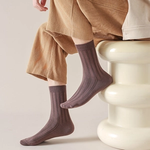 Close-up of brown ribbed mid-calf socks paired with corduroy pants for autumn style