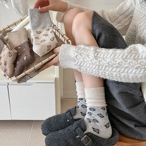 Detail of vintage leopard print knit crew socks in warm earth tones and ribbed cuffs