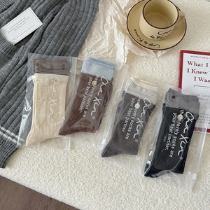 Detail view of four-color striped knit crew socks in premium individual packaging