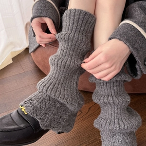Détail de jambières en tricot gris foncé avec bords festonnés et texture côtelée