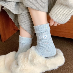 Warm light blue wool socks with colorful speckles and heart bow embroidery detail