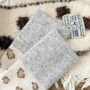 Detailed view of leopard print knit socks with gray ribbed cuffs for winter warmth