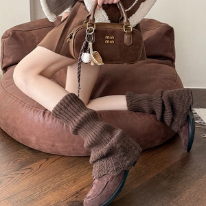 Détails de jambières en tricot marron foncé avec motif torsadé et bordure au crochet