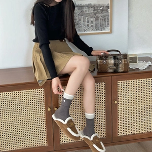 Grey striped knit socks paired with brown loafers and khaki pleated skirt for autumn