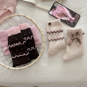 Detailed knit texture of wool socks featuring ruffles, buttons, and bow accents