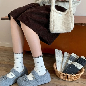 Detail of wool-blend crew socks featuring ruffled edges and vintage knit dot patterns