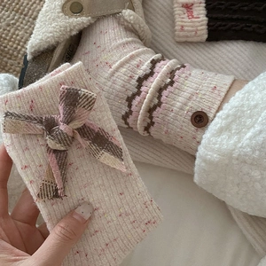 Thick wool socks with ruffle trim, colored flecks, wooden buttons and tartan bow detail