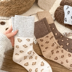 Detailed close-up of thick leopard print knit socks with high elastic ribbed cuffs