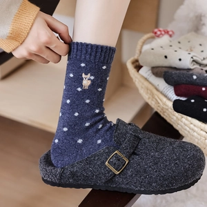 Close-up of navy polka dot wool socks with cute alpaca embroidery and felt slippers