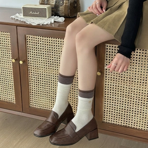 Retro dark brown square toe loafers paired with striped knit mid-calf socks for women