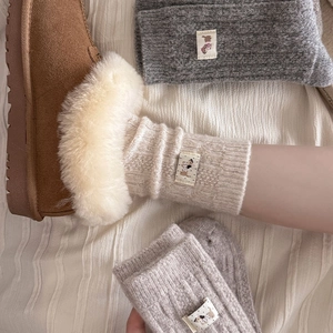 Detailed knit texture of wool socks featuring cute dog patch and thick warm lining