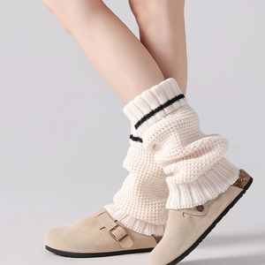 Chunky knit leg warmers in cream with black stripes, styled for a cozy winter look