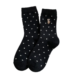 Retro black wool socks with white polka dots and cute deer embroidery on white background