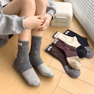 Detailed view of vintage wool blend socks featuring stylish distressed holes and fabric label