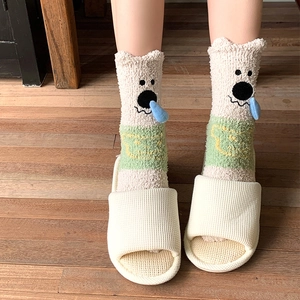 Close-up of cute cartoon pig coral fleece socks with 3D ears on wooden floor