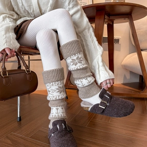 Close-up of retro knit leg warmers with snowflake pattern and ribbed cuffs in warm brown