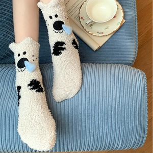 Detail of coral fleece socks with 3D blue heart on a cozy home background