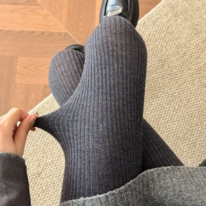 Detail shot showing the high elasticity and ribbed knit texture of dark gray wool leggings