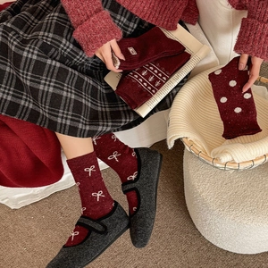 Detail view of red velvet bow and polka dot patterns on thick winter wool socks
