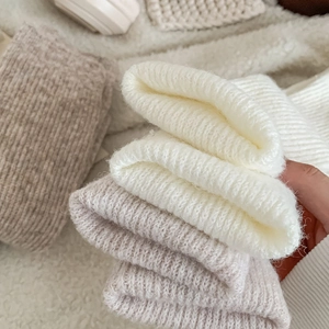 Detailaufnahme dicker gerippter Wollsocken in Weiß und Beige mit weicher Textur