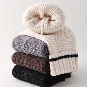 Detailed close-up of thick knit leg warmers showing ribbed textures in four classic colors