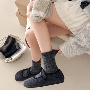 Close-up of thick grey cable knit thermal socks with wool Mary Jane home shoes