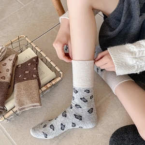 Cozy leopard print mid-calf socks for women featuring ribbed cuffs and soft knit texture