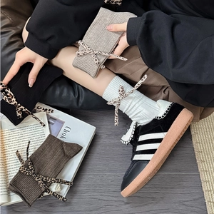 Detail of leopard print ribbon bows on rib-knit cotton mid-calf socks in various colors