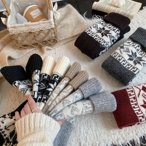 Detailed close-up of winter knitted leg warmers with Nordic snowflake patterns in multiple colors
