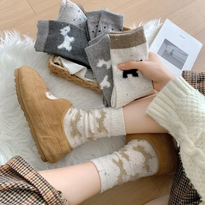 Detail von Fair-Isle-Stricksocken mit Hundemuster und gemütlichen Wildleder-Slippern